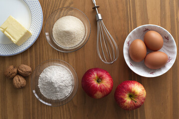 Ingredients for baking apple cake on wooden background sugar flour eggs flatlay
