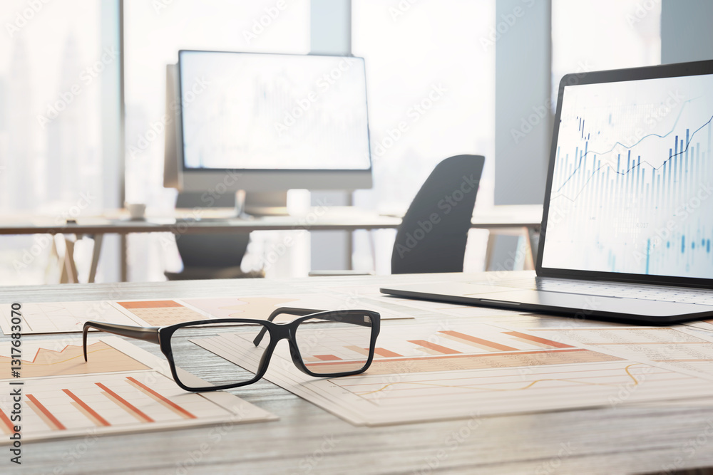 Poster financial reports and charts on a wooden office desk with glasses and a laptop displaying financial 