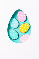 Polka dot Easter cookies inside an egg-shaped cutout. Festive holiday sweets.