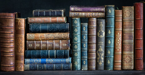 Old books on wooden shelf. Tiled Bookshelf background.  Concept on the theme of history, nostalgia, old age. Retro style.