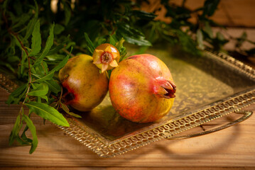 Pomegranates, beautiful freshly picked pomegranates on a wonderful tray on a rustic surface,...