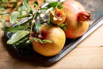Pomegranates, beautiful freshly picked pomegranates on a wonderful tray on a rustic surface,...