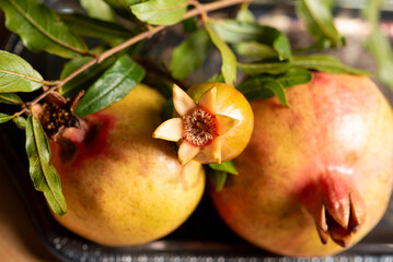 Pomegranates, beautiful freshly picked pomegranates on a wonderful tray on a rustic surface,...