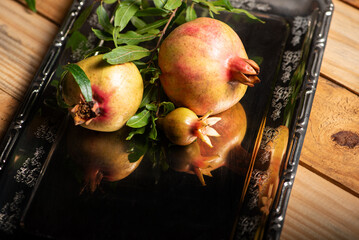 Pomegranates, beautiful freshly picked pomegranates on a wonderful tray on a rustic surface,...