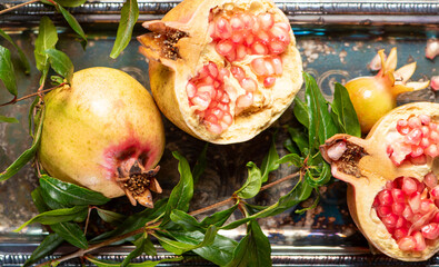 Pomegranates, beautiful freshly picked pomegranates on a wonderful tray on a rustic surface,...
