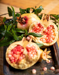 Pomegranates, beautiful freshly picked pomegranates on a wonderful tray on a rustic surface,...
