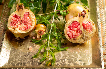 Pomegranates, beautiful freshly picked pomegranates on a wonderful tray on a rustic surface,...