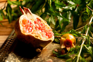 Pomegranates, beautiful freshly picked pomegranates on a wonderful tray on a rustic surface,...