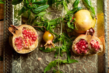 Pomegranates, beautiful freshly picked pomegranates on a wonderful tray on a rustic surface,...