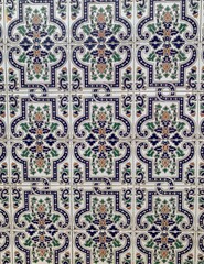 Vintage Andalusian ceramic tiles with intricate floral and geometric patterns in blue, green, and beige. Traditional ornamental design, perfect for backgrounds and decor. 