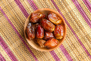 Dried dates fruits in wooden plate. Kurma popular during Ramadan. Top view