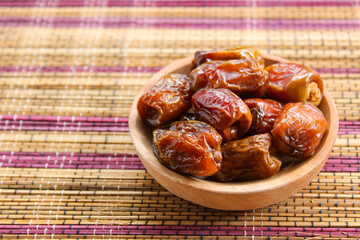 Dried dates fruits in wooden plate. Kurma popular during Ramadan