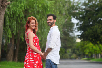 Obraz premium portrait of young cheerful couple in love in the park on summer day