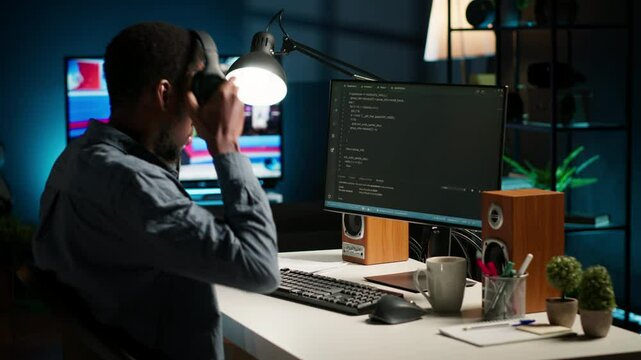 African american male programmer working on cloud computing with an algorithm, writing code for optimization on terminal window. IT specialist inserts html code, server security. Camera B.