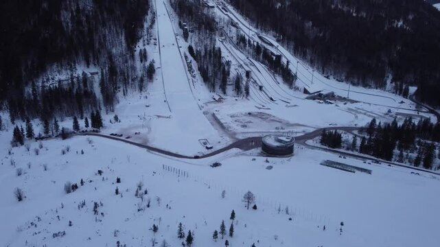 4k aerial drone panorama of Planica flying hill with many ski jumps visible in early morning