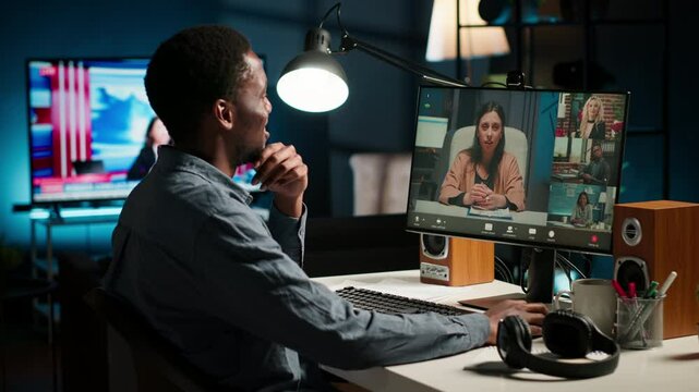 African american male freelancer engaged in online discussion with workmates on his laptop, joining a conference on web. Black guy video conferencing on a call with coworkers on pc. Camera B.