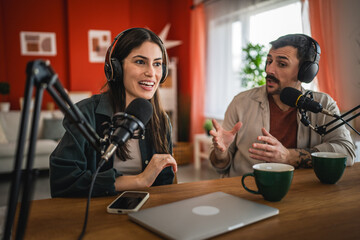two young adult hosts record together podcast in home studio