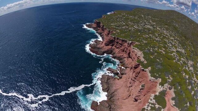 Towering red rock cliffs overlooking turquoise waters, revealing pristine coastal wilderness of western australia's rugged esperance shoreline