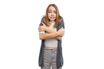 A young woman with a worried expression, hugging herself to stay warm against a white background.