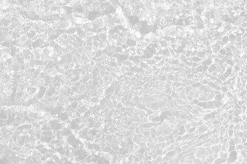 White water with ripples on the surface. Defocus blurred transparent white colored clear calm water surface texture with splashes and bubbles. Water waves with shining pattern texture background.