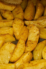 Baked potato slices with seasoning mixture. Close-up.