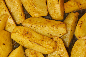 Baked potato slices with seasoning mixture. Close-up.