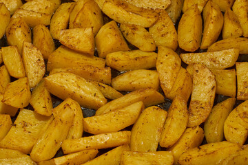 Baked potato slices with seasoning mixture. Close-up.