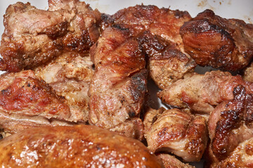 Skewered kebabs and homemade sausages in a white porcelain mold. Close-up.