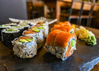 Japanese sushi rolls with salmon, avocado and cream cheese on black background, close-up. 