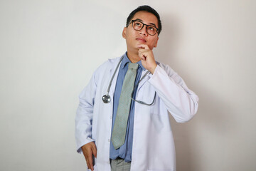 medical doctor with hand on chin looks contemplative up. Isolated on white background.