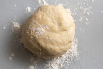A ball of freshly made dough sits on a lightly dusted surface, ready for baking into bread, pastries, or any culinary creation.