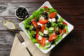 Delicious fresh Greek salad on wooden table, top view