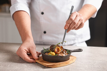 Professional chef serving dish at table indoors, closeup