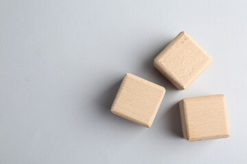 Wooden cubes on light grey background, flat lay. Space for text