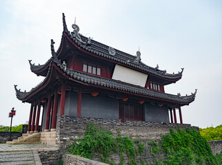 A traditional Chinese building features an intricately designed roof supported by a sturdy stone base.