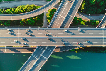 Aerial of vehicles navigate a complex highway system, showcasing overpasses and intersections.