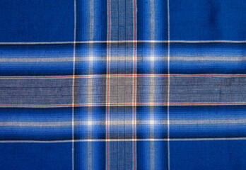 The pattern and texture of the blue, black and white cotton striped and checker fabric, a motif that is often used on sarongs in Indonesia.