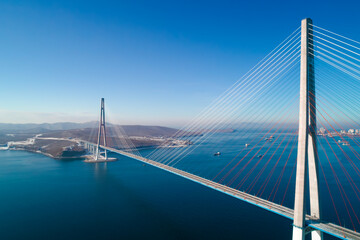Stunning view of the Russky Bridge in Vladivostok with clear blue skies and tranquil waters.