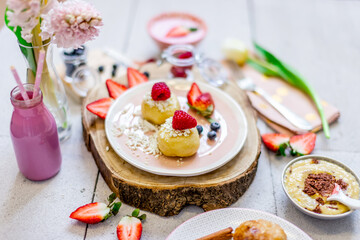 Fresh yoghurt and cake with strawberries and young spring flowers.