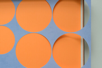 paper stencil with circle cutouts on the edge of a cardboard box and blank paper