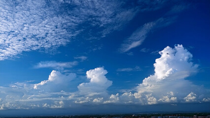 Majestic Cumulus Clouds Against a Deep Blue Sky Over a Scenic Landscape