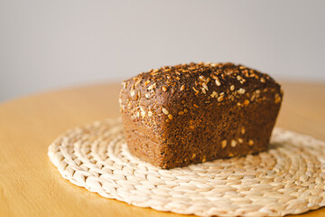 Sourdough bread, freshly baked and still warm, are stacked on a wooden surface. The bread are covered in seeds sesame and sunflower, adding a rustic and flavorful touch.