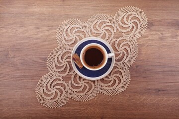 A cup of Turkish Tea with a small chocolate piece sits on a saucer, placed on an intricately...