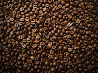 Obraz premium A steaming cup of coffee surrounded by scattered coffee beans.