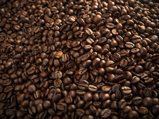 A steaming cup of coffee surrounded by scattered coffee beans.