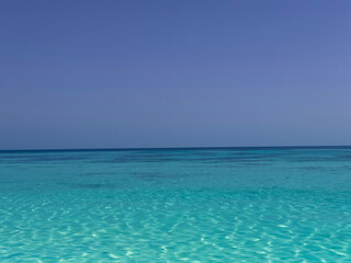The  Nature of sea beach in summer with sunlight, sandy beach The sparkling sea water contrasts with the blue sky bakground