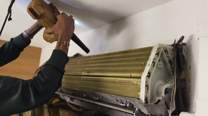 A technician repairs a wall mounted air conditioner and fixing HVAC systems