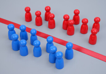 Blue and red wooden people figures separated by red line.