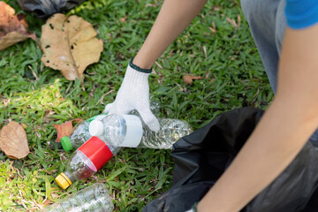 Fototapeta premium Volunteer collecting plastic bottles during an environmental cleanup