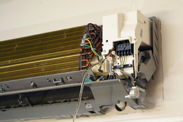 The worker cleans and repairs the air conditioner to ensure it operates properly